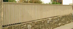 langer blickdichter Zaun auf einer Mauer